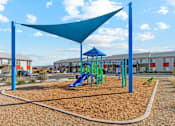 Thumbnail 12 of 36 - A playground with a blue shade structure and a green slide.