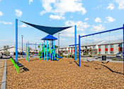 Thumbnail 13 of 36 - A playground with a blue shade structure and a swing set.