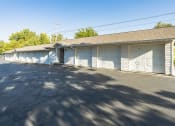 Thumbnail 28 of 34 - a white garage with white doors and a street in front of it