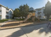 Thumbnail 25 of 34 - a playground with a slide in front of an apartment building