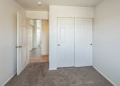 Thumbnail 18 of 34 - a bedroom with two closets and a door to a hallway