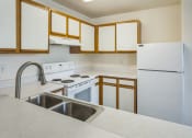 Thumbnail 5 of 34 - an empty kitchen with white appliances and white cabinets