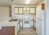 Thumbnail 1 of 34 - an empty kitchen with white appliances and wooden cabinets