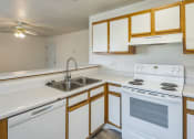 Thumbnail 2 of 34 - an empty kitchen with white appliances and wooden cabinets