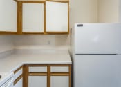 Thumbnail 4 of 34 - an empty kitchen with a refrigerator and cabinets