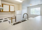 Thumbnail 3 of 34 - an empty kitchen with white appliances and a sink