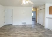 Thumbnail 10 of 34 - an empty living room and kitchen with white walls and wood flooring