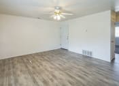 Thumbnail 8 of 34 - an empty living room with white walls and a ceiling fan