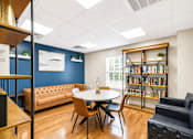 Thumbnail 4 of 17 - A room with a round table and chairs, a bookshelf, and a couch.