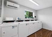 Thumbnail 8 of 16 - A row of white washing machines in a laundromat.