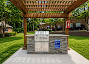 Thumbnail 4 of 13 - Outdoor grill station with pergola and stone surround at Stratford Arms Apartments, Georgia