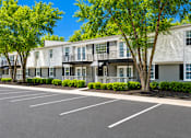Thumbnail 2 of 9 - A parking lot in front of apartment buildings.
