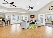 Thumbnail 10 of 37 - A spacious living room with a kitchen area in the background.