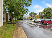 Thumbnail 21 of 22 - A wet street with cars parked on the side.