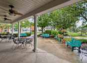 Thumbnail 22 of 22 - A patio with a table and chairs under a roof.