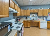 Thumbnail 16 of 22 - A kitchen with wooden cabinets and a black stove top.