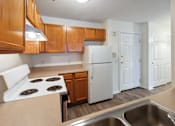 Thumbnail 6 of 22 - A kitchen with a white refrigerator and a white stove top oven.