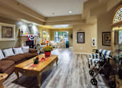 Thumbnail 15 of 22 - A living room with a brown couch and a wooden coffee table.