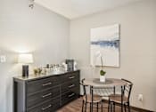 Thumbnail 8 of 24 - A dining table with chairs and a cabinet with drawers is in a room.