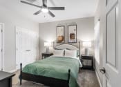 Thumbnail 14 of 30 - a bedroom with a bed and a ceiling fan