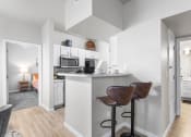 Thumbnail 6 of 30 - an open kitchen and living room with a bar and stools