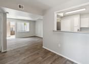 Thumbnail 5 of 56 - an empty living room and kitchen with white walls and wood flooring at Vista Linda, Santa Fe, 87507