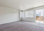 Thumbnail 16 of 56 - the living room of an apartment with carpet and a door to the patio at Vista Linda, Santa Fe, New Mexico