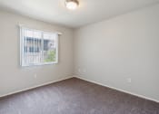 Thumbnail 22 of 56 - an empty room with carpet and a window at Vista Linda, Santa Fe, NM 87507