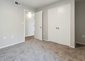 Thumbnail 13 of 56 - an empty room with white doors and a carpeted floor at Vista Linda, Santa Fe, NM