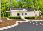 Thumbnail 3 of 9 - A small building with a parking lot in front of it.