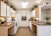 Thumbnail 21 of 24 - A kitchen with white appliances and wooden cabinets.