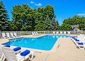 Thumbnail 9 of 21 - Outdoor swimming pool with lounge chairs and towels at Northview Park Apartments, Michigan