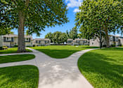 Thumbnail 5 of 9 - A residential area with a pathway and houses.