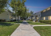 Thumbnail 16 of 16 - a walkway between houses with trees and grass