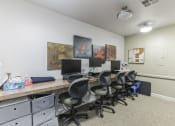 Thumbnail 10 of 16 - a room with a long desk with computers and chairs