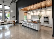 Thumbnail 6 of 16 - A modern kitchen with a dining table and chairs.
