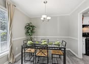 Thumbnail 5 of 28 - A dining room with a glass table and chairs.