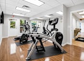 Thumbnail 13 of 24 - A gym with a row of exercise bikes and a television mounted on the wall.