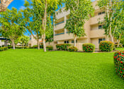 Thumbnail 2 of 7 - A building with a green lawn in front of it.
