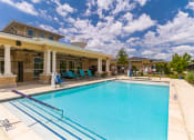 Thumbnail 10 of 26 - a swimming pool with a house in the background