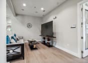 Thumbnail 18 of 26 - a living room with couches and tables and a television