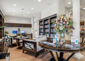 Thumbnail 20 of 26 - a living room with a table and chairs and a library