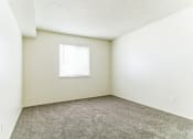 Thumbnail 6 of 13 - a bedroom with white walls and carpet