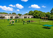 Thumbnail 3 of 16 - A playground area with a green slide, a green bench, and a green trampoline.