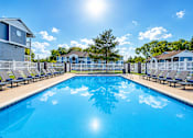 Thumbnail 2 of 10 - Outdoor swimming pool with lounge chairs at Creekview Apartments, Midvale, Utah