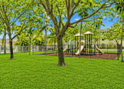 Thumbnail 4 of 10 - A playground with a slide and a swing set.