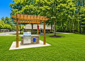 Thumbnail 4 of 9 - A wooden pergola with a grill on a patio.