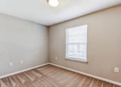 Thumbnail 10 of 26 - an empty living room with a window and a wooden floor