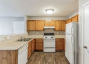 Thumbnail 6 of 26 - a kitchen with white appliances and wooden cabinets