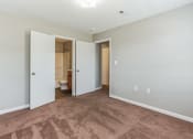 Thumbnail 9 of 26 - an empty living room with a door leading to a bathroom